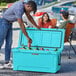 A man wearing a hat putting a can of beer into a Sky Blue CaterGator outdoor cooler.