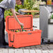 A man putting a beer into a CaterGator outdoor cooler.