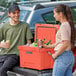A man and woman standing next to a CaterGator outdoor cooler.