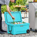A man putting a can into a CaterGator outdoor cooler.