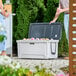 A man and woman standing next to a CaterGator outdoor cooler with the lid open.