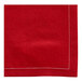 A red cloth napkin with a white stitch.
