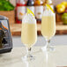 Two yellow drinks made with Live Pure Epic Mango Smoothie cubes on a counter.