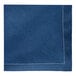 A navy blue cotton cloth napkin with white stitching.