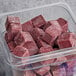 A plastic container on a counter filled with red Live Pure strawberry acai smoothie cubes.