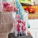 A person pouring Live Pure Pitaya Passion Fruit smoothie cubes into a blender.