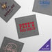 A customizable grey square cotton dinner napkin with blue text.