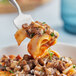 A fork with pasta and Phillips Gourmet Mushrooms Blend-Ready IQF roasted diced mushrooms on it.