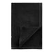 A black cloth napkin with white stitching folded on a white surface.