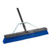 A blue Lavex push broom with a black metal handle.
