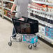 A man pushing a Regency black plastic grocery cart in a grocery store.