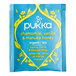 A case of Pukka Organic Chamomile, Vanilla, and Manuka Honey tea bags on a table in an organic food store.