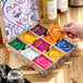 A hand holding a box of Pukka Organic Selection Tea