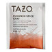 A white Tazo packet with orange and white text filled with pumpkin spice chai tea bags.