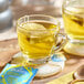 A glass mug of Pukka Organic Chamomile, Vanilla, and Manuka Honey tea with a tea bag on a coaster.