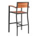 A Lancaster Table & Seating Axel Series black outdoor barstool with brown faux teak slat seat and arms.