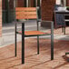 A Lancaster Table & Seating Axel outdoor chair with brown faux teak slats and black metal arms.