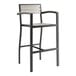 A black outdoor barstool with gray faux teak slat seat and arms.