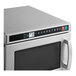 A close-up of a Solwave Space Saver stainless steel commercial microwave with a digital display.