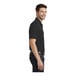 A person wearing a Port Authority Deep Black short sleeve polo shirt.