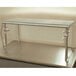 An Advance Tabco single tier self service food shield with metal legs on a counter over a salad bar.