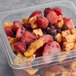 A plastic container of Wyman's frozen mango and wild blueberries.