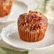 A muffin with Wyman's sliced cranberries and nuts on a white plate.