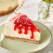 A slice of cheesecake with Wyman's frozen strawberries on top.