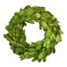 A Mills Floral Company preserved boxwood candle ring with green leaves.