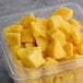 A plastic container of Wyman's frozen mango chunks.