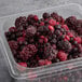 A plastic container of Wyman's frozen berries on a table.