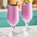 Two glasses of pink smoothies with strawberries and blueberries made with Wyman's mixed berries.