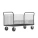 A gray metal wire cage cart with four wheels.