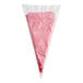 A White Toque gluten-free vegan raspberry mousse cone in a plastic bag.