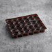 A White Toque black flared tart shell tray with holes in it.