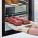 A person holding a plate with a White Toque gluten-free vegan chocolate and berry cake slice.