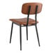 A Lancaster Table & Seating mid-century black chair with cognac vinyl padded seat and backrest.