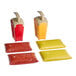 A set of four Heinz plastic countertop pump dispensers in red and yellow with white lids and handles.
