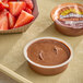 A bowl of SunButter chocolate spread next to strawberries.