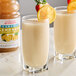 Two glasses of Dr. Smoothie Classic Lemonade with lemon slices and straws.