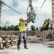 A man in a yellow vest using a Karcher electric cold water pressure washer.