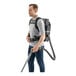 A person wearing a Karcher BVL 5/1 BP cordless backpack vacuum.