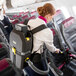 A woman using a Karcher cordless backpack vacuum to clean a chair.