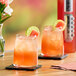 Two glasses of SHOTT Watermelon and Lime energy drink on a table.