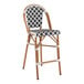 A Lancaster Table & Seating black and white birdseye weave rattan outdoor barstool.
