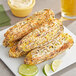 A plate of grilled corn with lime wedges and a slice of lime on a plate.