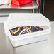 A white Vollrath plastic container with food in it.