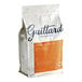 A white and orange bag of Guittard Lever du Soleil Semi-Sweet Wafers on a white background.