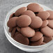 A bowl of Guittard Eclipse du Soleil milk chocolate wafers.