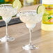 Two glasses of Texas Roadhouse Margaritas on a table with a lime slice.